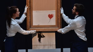 Banksys verk Love is in the bin, eller Balloon girl som den ursprungliga versionen hette innan bilden strimlades under pågående auktion. Banksys verk Balloon Girl, eller Love is in the Bin som den senare har omnämnts som, visas upp på Sotheby's i London.