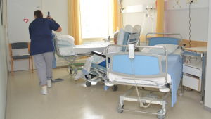 En socionom som arbetar inom barnomsorgen kan i stället arbeta inom vården om daghemmet stängs på grund av coronaviruset. En städare torkar golv i ett rum på en bäddavdelning.