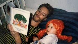 Just nu bygger Siri Fagerudd sin skådespelarkarriär i Stockholm, men i Österbotten kommer Siri alltid vara “Fagerudds flicko”. Här med pappa Johan Fagerudd. En liten flicka med pippi långstrump-peruk ligger i sängen. Hennes pappa läser en saga till henne.
