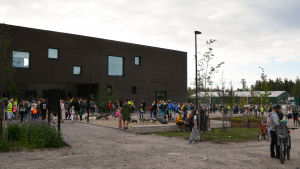 Många föräldrar ville vara närvarande på barnens första skoldag. Skolbyggnaden och många männiksor ute på gården.