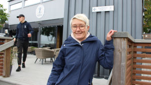 Företagare Petra Rehnström säger att restaurangerna haft en fin säsong. Men Hangö behöver mera hotellkapacitet. Kvinna i blått vid hamnkontoret i hamnen