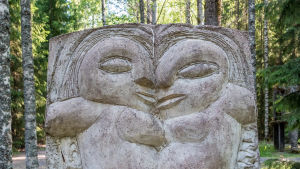 En stenstaty som föreställer två ansikten.