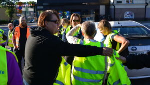 Minna Mannonen säger att det ofta är svårt att hitta frivilliga att övervaka trafiken vid skolstarten. Minna Mannonen delar ut västar vid Lovisa torg.