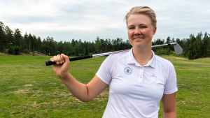 Matilda Svahn siktar mot att bli professionell golfare. Hennes handicap är + 2,4. En ung kvinna står på en gräsmatta och håller en golfklubba över axeln.