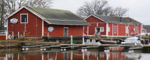 Gnägget som fanns i hamnmagasinet till höger fungerade som diskotek till år 1991, i Lindqvists regi till år 1986. I bakgrunden skymtar sommarrestaurang Knipan som Lindqvist också har haft hand om. röda bodar i en hamn