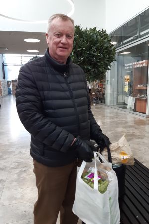 Raul Henriksson handlar mindre mat för eget bruk den här påsken. Gästerna runt middagsbordet är färre. Foto på Raul Henriksson som står med två välfyllda matkassar.