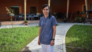 Avdelningsskötaren Mikaela Räfsbäck Kvinna i vårdkläder står på en innergård.