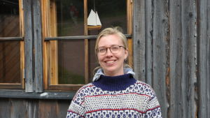 Daniela Grotenfelt. Närbild på Daniela Grotenfelt som står invid båtmuseet i blåvitmönstrad ylletröja.