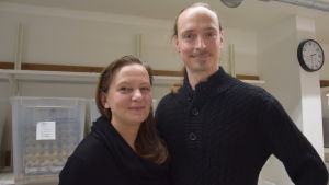Petra och Roope Päivänen experimenterar en hel del i det egna köket. Förutom syrsor producerar gården också höns- och vaktelägg som säljs på rekoringar. En kvinna och en man står nära varandra. I bakgrunden stora genomskinliga plastlådor. Finns gräshoppor i dem. men de syns inte.