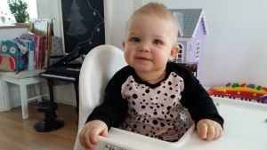 Elin är ofta iklädd kläder som mamma har sytt själv. Litet barn sitter i matstol iklädd kläder som mamma har sytt