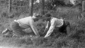 "Dra pissmyra", Bromarf 1930. Två män leker leken "Dra pissmyra". Bilden är tagen 1930 i Bromarf.