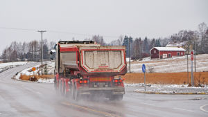 Längs Oljevägen åker mycket tung trafik - oljebilar på väg till Sköldvik och lastbilar på väg till olika grustag. Lastbil kör i korsning