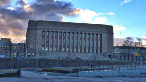 Riksdagshuset i Helsingfors fotat rakt framifrån i kvällsljus. 
