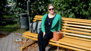 Annika Langinvainio hörde om nyheten på morgonen via sin kompis. En kvinna som sitter på en gul parkbänk.