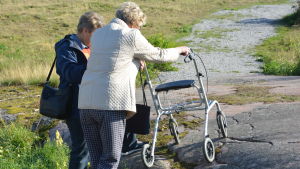 Klipporna är problematiska om man har rullator. Lisbet Tuominen hjälper Dorrit Söderblom upp med rullatorn på en bergssluttning.