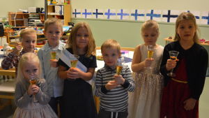 Längst fram till vänster Wilma Renfors, Viggo Söderholm, Anton Sundström, Maja Björkman (som fru Jenni Haukio), Kasper Ström, Alva Renfors, Maja Jensén vid Sofia daghem i Västanfjärd. Barn skålar.