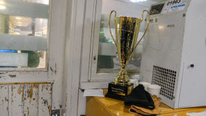 Inne vid dörren till omklädningsrummet ståtar en fin pokal. Ett kärt minne från segern i den finländska cupen. Pokal i omklädningsrum.