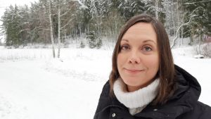 Polisen har under coronatiden fått fler uppdrag till hemmen, konstaterar Saija Westerlund-Cook. Hur påverkar det barnen? Saija Westerlund-Cook, en dam med rakt mörkt hår, står i ett snöigt åker- och skogslandskap.