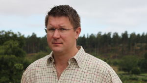 Mikael Jensen, förvaltare på Söderlångvik gård. En man klädd i vitrutig skjorta ser in i kameran.