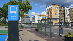 En del av Nickby bussterminal. Till vänster syns en skylt som det står Nickby på, till höger syns en busshållplats invid Stora Byvägen. Det är en del av Nickby bussterminal som syns.