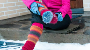 Tätaste sockan överst, tipsar Rosenström. Yllesockor i orange, blå och röda toner syns när en kvinna sitter på en trappa.