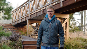 Jonas Lundberg blev inte särskilt överraskad när han hörde om Vastaamo-intrånget. Det sätt som förövaren använt informationen för att göra pengar är däremot ovanligt brutalt, menar han. Jonas Lundberg går vid en gångbro i trä.