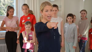 Koreografen Jessica Öller visar och barnen lyssnar. Danslärare och koreografen Jessica Öller visar för barnen hur de ska dansa.