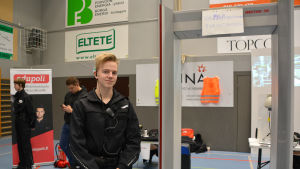 Lukas Willner studerar på Edupoli. Den frivilliga säkerhetskontrollen pipade till när Yle Östnylands reporter gick genom porten. lukas klädd i vaktkläder vid en säkerhetsport på lets go mässa i lovisa
