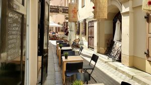 Restaurang i Vilnius Gamla stad väntar på kunder till sin uteservering. Bilden är från sommaren 2019. Restaurang i Vilnius, Litauen väntar på kunder till sin uteservering.