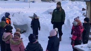 På Vestersundsby daghem i Jakobstad satsar man på uteliv och att klara sig i olika situationer. En kvinna står med nio dagisbarn i en halvcirkel på en snöig gårdsplan.