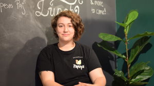 Samira Zaoui-Nyberg har drivit salladskaféet på Kungsgatan i Ekenäs sedan mitten av juni. En kvinna sitter. I bakgrunden en svart tavelvägg. Skrivet med vit krita dagens lunch.