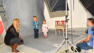 Hampus och Hilma funderar länge tillsammans med fotografen Kjell Svenskberg och mamma Stephanie Grönroos om de ska sitta på pallen eller inte. Mamma Stephanie Grönroos med sina barn Hampus och Hilma som ska fotograferas i en studio av Kjell Svenskberg.