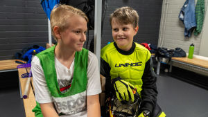 Visst orkar man med träningar genast efter skolan, tycker både Robin Puuronen och Simon Valros. Två innebandyspelare sitter i omklädningsrummet.
