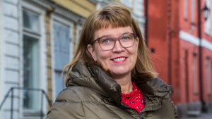 Mikaela Nylander önskar att diskussionen om stadens konst skulle fortsätta bland politikerna. Arkivbild. Leende kvinna står bland trähus
