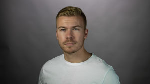 Musikkoordinator Joel Edström skrev sitt slutarbete om Tiktok. En vit man i en fotostudio. Han ler litet och ser in i kameran.