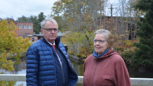 Göran Lindholm och Kerstin Ilander känner Svartås historia som sina egna fickor. Svartåborna Göran Lindholm och Kerstin Ilander med kraftverket och SBA Interior i bakgrunden.