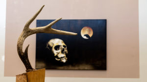 Skulptur, Skogens ande av Winfrid Zakowski. Målning, Hello Darkness My Old Friend, Pike Kukkonen. Bildkonst på utställning.