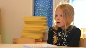 Edith Sevon, 6 år, tycker om att gunga med kompisarna. Edith Sevon, 6 år, vid bord på Solbacka daghem i Karis.