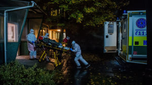 Ett ungerskt ambulansteam förflyttar en coronapatient från intensivavdelningen på Jahn Ferenc-sjukhuset i Budapest till ett annat sjukhus. Ett ungerskt ambulansmanskap förflyttar en coronapatient från intensivavdelningen på ett sjukhus i Budapest till ambulansen.