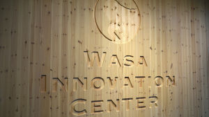Huset har massiva träväggar. Wasa Innovation Center, logotyp infälld i trä.
