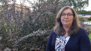 Bildningsdirektör Tina Nordman är missnöjd med regeringens förslag. En kvinna utomhus framför att träd och en buske.