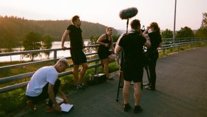 I väntan på det perfekta ljuset under filminspelningen. Ett filmsinpelningsteam står vid en vägkant och väntar.