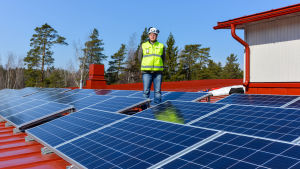 Kommuner börjar alltmer utnyttja solenergi. Här Borgå stads projektingenjör Tony Lökfors på taket till Grännäs nya skola i Borgå (Arkivbild). Tony Lökfors uppe på tak med solpaneler.