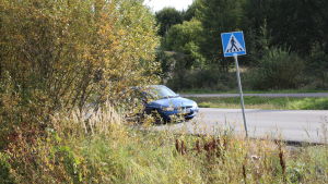 Dåligt sikt i den här korsningen i Haiko, bilister och fotgängare kan överraska varandra om de inte är uppmärksamma. Bil skymd bakom löv.