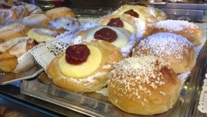 För många människor slinker det lätt ner lite bullar och kakor med kaffet. Vitrin med lockande kaffebröd på ett café.