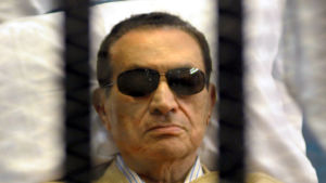 Mubarak låg tidivs i sjuksäng under rättegången 2012. Egyptens störtade president Hosni Mubarak bakom galler 2012.