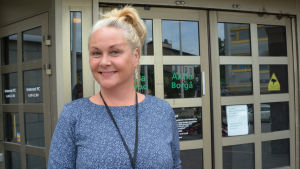 Niina Kärkkäinen framför Aktias kontor i Borgå. Niina framför Aktias dörr i Borgå