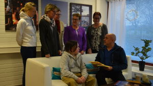 I soffan Jonas och Johan "Jussi" Lindberg. Bakom soffan Susann Fagerlund, Susanne Sigfrids, barnomsorgschef Mary-Anne Fröberg, Eivor Mattsson och Malin Joki. Fem kvinnor står bakom en soffa. Två män sitter i soffan.