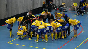 Goda råd var dyra när det stod 4–2 inför sista perioden. Spelare som står på huk i en ring.
