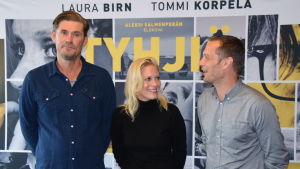 Tommi Korpela, Laura Birn och regissören Aleksi Salmenperä Skådespelarna Tommi Korpela och Laura Birn tillsammans med regissören Aleksi Salmenperä står framför filmplanschen till Tyhjiö.